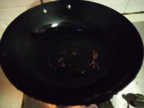 准备一口铁锅，倒入植物油热锅，先加入八角跟花椒，小火炒香。