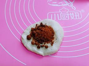 取一块面团，用擀面杖擀圆饼，放上红糖。