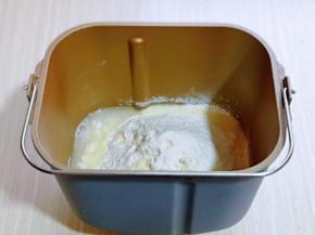 首先将玉米油与鸡蛋，牛奶，奶粉，馒头自发粉，加入面包桶中。