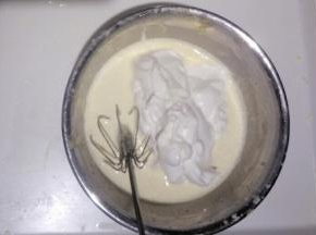 把蛋白全部倒入蛋黄糊中，翻拌(5~6次)成不均匀状态。