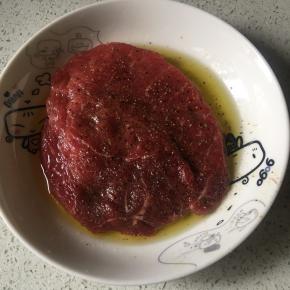 首先牛排抹盐，再抹黑胡椒碎，再抹上橄榄油腌制1个小时，或者（上午腌制下午煎牛排）最好