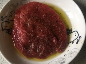 首先牛排抹盐，再抹黑胡椒碎，再抹上橄榄油腌制1个小时，或者（上午腌制下午煎牛排）最好