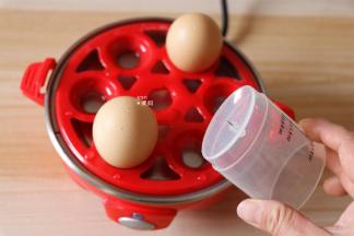 用钢针将鸡蛋大头一端戳一个小洞（这样可以避免鸡蛋破裂），放入蒸蛋器的蒸架上；