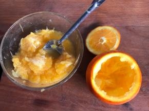 把鲜橙在四分之一处切开，挖出果肉