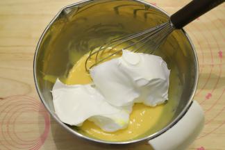 取三分之一的蛋清加入到蛋黄糊内，蛋抽画半圈的方式将蛋清和蛋黄糊混合均匀。