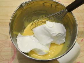 取三分之一的蛋清加入到蛋黄糊内，蛋抽画半圈的方式将蛋清和蛋黄糊混合均匀。