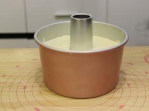 倒入七寸日式梯形加高活底蛋糕模内，从离桌面3公分的地方轻轻震一下去气泡。