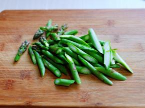 将芦笋的根部切掉，用冷水冲洗干净，斜切小段。