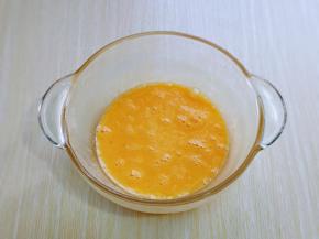 首先将鸡蛋磕大口器具中，用手动打蛋器打散。