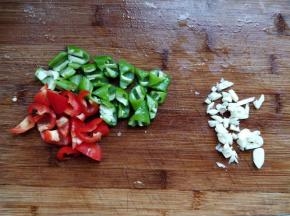 将青红椒洗净，去蒂后切小块，大蒜拍扁剁碎。