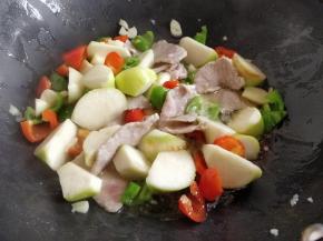 倒入肉片，滑炒到半熟后，加入茭白和盐大火快炒。