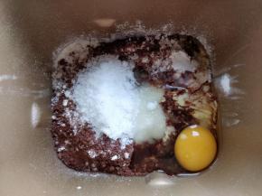 在牛奶表面倒入高筋粉覆盖住，再倒入可可粉、细砂糖、盐、鸡蛋和植物油。不要让酵母粉直接接触糖和盐，以免影响发酵效果。