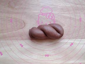 将长条对折，两手拿着两端朝相反方向拧，拧成麻花状。