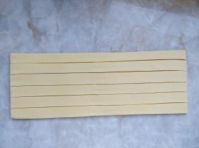 11. 号角酥整形：把冷冻松弛好的酥皮面团擀成长方形，切成均匀的细条。