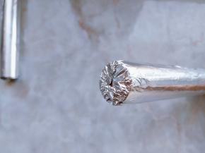 12. 制作卷筒：把锡纸（或耐高温油布）卷成筒状。油布的支撑力比锡纸好，单独用锡纸筒的话，加热后容易压塌，最好在锡纸内层再加一张纸，一起卷成筒。把锡纸一端捏和成如图状态，固定好。如果用油布，可忽略此步骤。