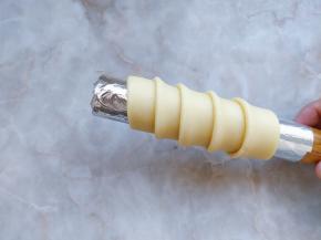 13. 定型：将条状酥皮缠绕在圆筒上。