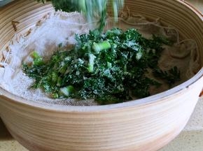 拌均匀的米粉茼蒿直接倒在屉布上，用筷子稍稍整理均匀，但不要压，让茼蒿保持松散的状态。