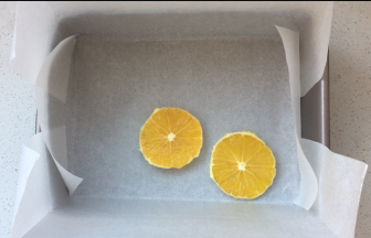 1、学厨9存烤盘（其他模具酌情增减量）内放一张油纸，将香橙皮去掉，切片，摆放在烤盘内