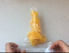 2、将橙子切成块，放入一个裱花袋中，用手将橙汁按压出来备用