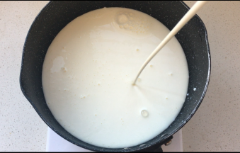 将牛奶，淡奶油，糖放入到奶锅中加热，直到糖融化，边缘冒小泡离火