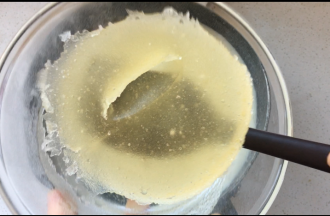 5、将已经膨胀的吉利丁块加入到牛奶中搅拌均匀，加入裱花袋中的橙子汁