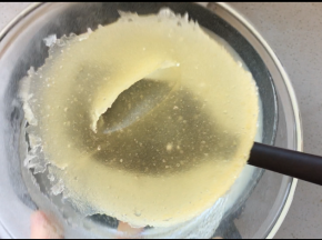 5、将已经膨胀的吉利丁块加入到牛奶中搅拌均匀，加入裱花袋中的橙子汁