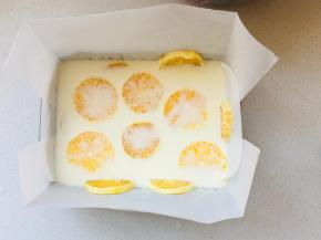 7、过滤后的牛奶溶液倒入到之前放好橙子片的烤盘内，放入冰箱冷藏2个小时凝固，取出后翻转，轻轻撕掉油纸即可