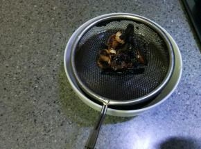 炸成焦状，隔一个网筛把热油倒进味极鲜碗里