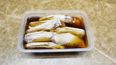 将糟卤（上海宝鼎牌）倒入盒子中，浸没鹅翼