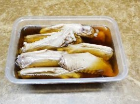 将糟卤（上海宝鼎牌）倒入盒子中，浸没鹅翼