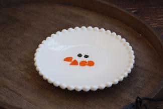 先将胡萝卜切成薄薄的圆片，然后再剪出鱼嘴巴形状，如图。 用海苔剪出眼睛的形状，如图。