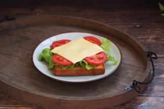 在烤好的土司上上放上生菜、番茄片和芝士，