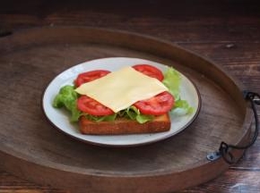 在烤好的土司上上放上生菜、番茄片和芝士，