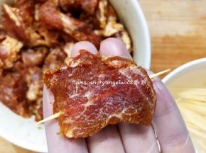 把腌制好的猪颈肉用牙签串起来，依次把所有猪颈肉串好