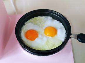 磕入两个鸡蛋磕入煎盘里，轻轻的转动不粘煎盘，使蛋清均匀。可以借助筷子将蛋黄固定在中间或者你想要的位置。