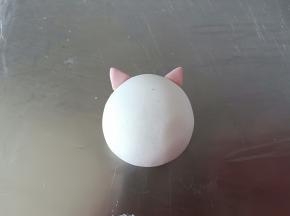 包入黑芝麻馅(这一步忘记拍照了)，用推的手法收口，滚圆后取适量红色面团做猪猪的耳朵，粘的时候刷一点点水就可以(说湿不湿的那种状态)，刷太多反而粘不住