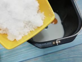 在把白糖倒入面包桶的一角