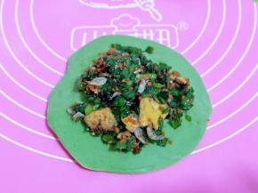 取一块小面团，用擀面杖擀圆饼，加入馅料。