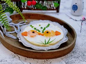 盛出装盘，将心形胡萝卜做鱼尾巴，圆形的胡萝卜做嘴巴，葱花做装饰，吐泡泡的鱼，韭菜叶子装饰水草，海苔煎两片圆形，做眼睛。