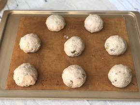 发好的面团排气后分割成8份，盖保鲜膜松弛30分钟，然后再次排气滚圆放在烤盘上盖上保鲜膜进行二发。