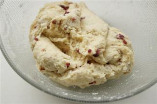 加入蔓越莓碎，继续折叠翻拌几下，使蔓越莓大致均匀的分布在面团内即可。