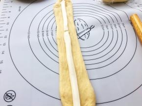 再擀成长椭圆条，将芝士条放在中间。