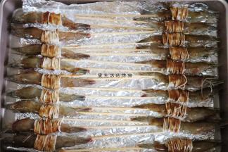 处理好的虾全部放入铺了锡纸的学厨烤盘里，将黑胡椒酱加入1勺花生油和2勺清水拌匀成比较稀的酱汁，涂抹在虾身上。