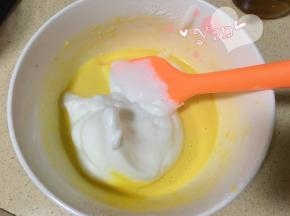 舀一大勺蛋白到蛋黄糊里。