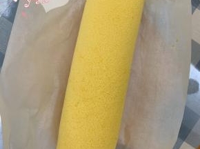 用擀面杖卷住油纸，顺势往上推，卷起来，两边跟拧糖一样拧起来。放入冰箱冷藏半小时后再切块食用。