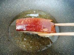 五花肉用厨房用纸吸干表面多余的水分，肉皮朝下，炸至金黄色，肉皮暴起后捞出备用