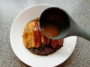 把准备好的酱汁淋在扣肉上面，即可食用。