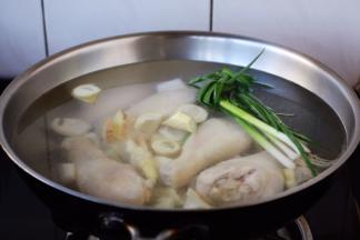 大火置锅，温水或者开水放入春笋和鸡腿、小香葱、姜。