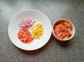 利用面团发酵的时间准备好披萨馅料：培根肉切成小片，洋葱红萝卜洗干净切成小丁，准备好熟的玉米粒。
