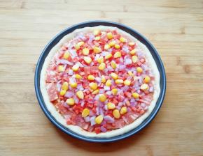 均匀的撒上洋葱、红萝卜和玉米粒。